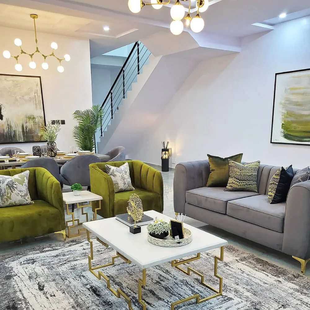 Gray couch paired with olive green accent chairs and gold coffee table in a modern living room