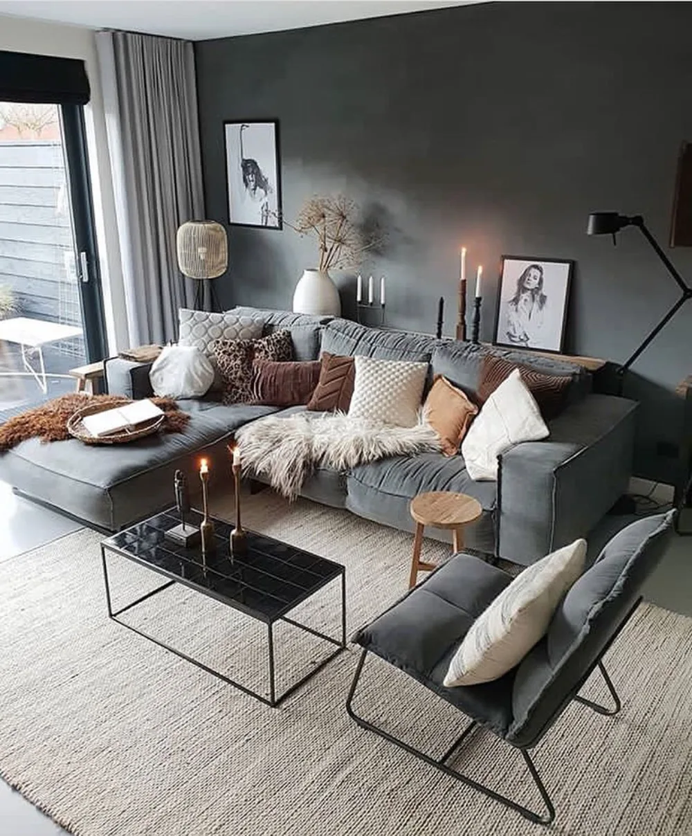 Gray sectional sofa against a dark charcoal wall with neutral textured pillows