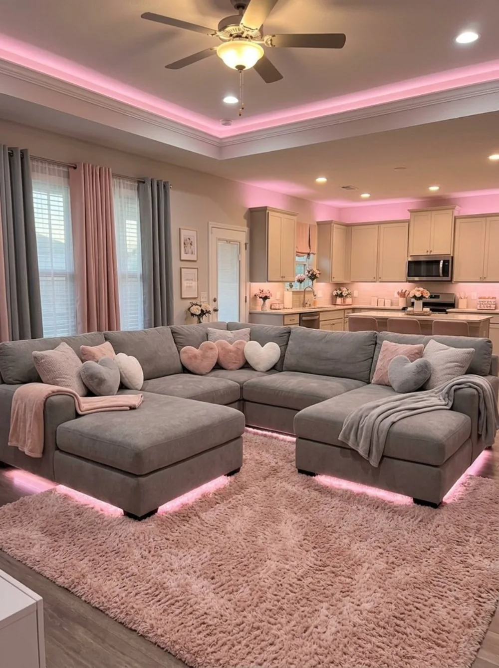 Gray sectional sofa decorated with blush pink pillows and soft pink lighting