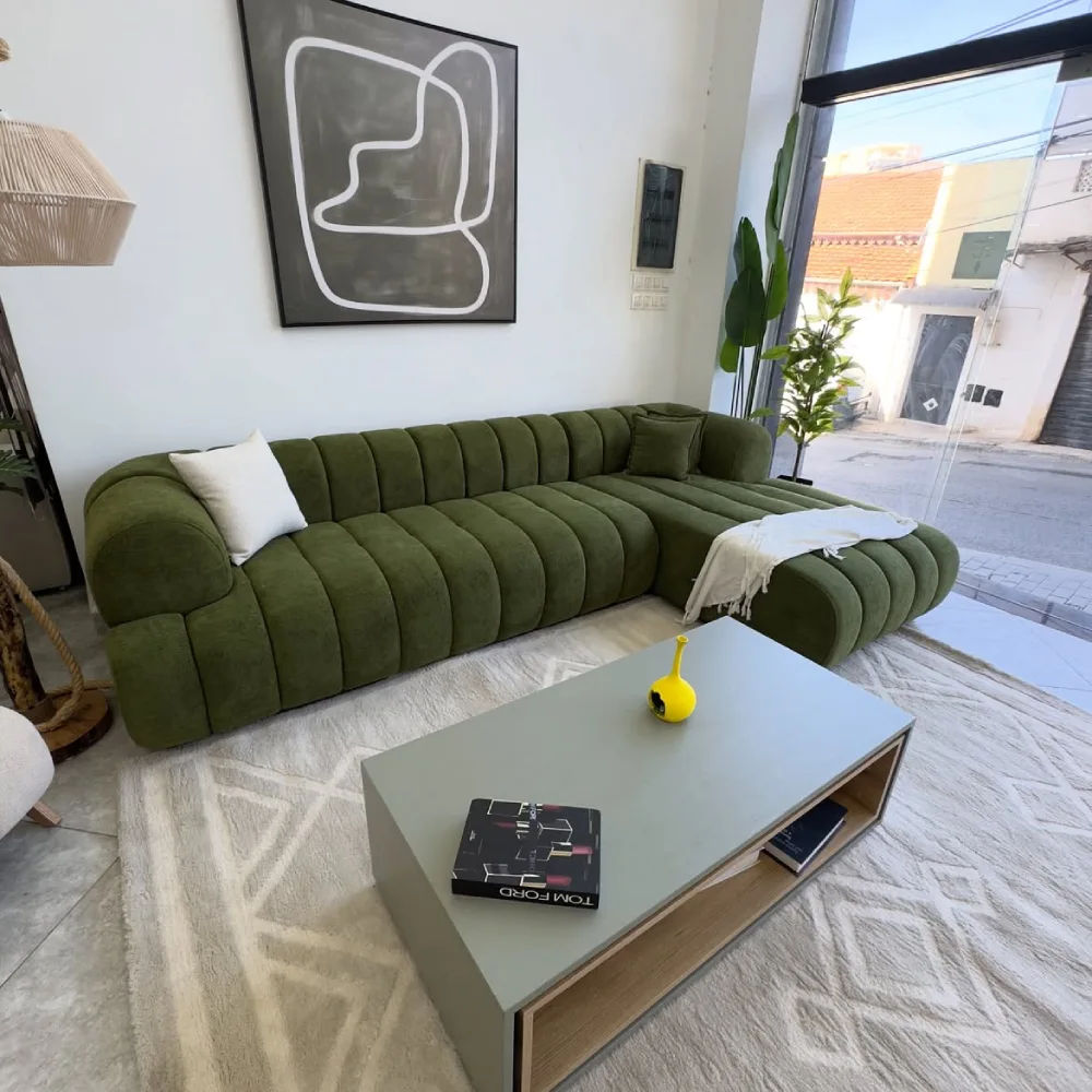 Olive green curved sectional sofa with minimalist decor and a light coffee table