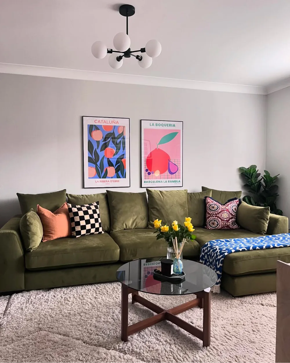 Olive green sectional sofa with colorful pillows and Barcelona artwork