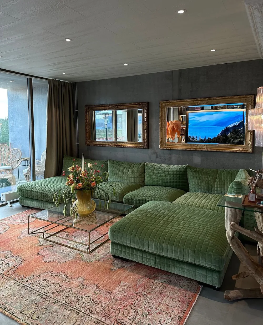 Green quilted sectional sofa against a dark charcoal wall