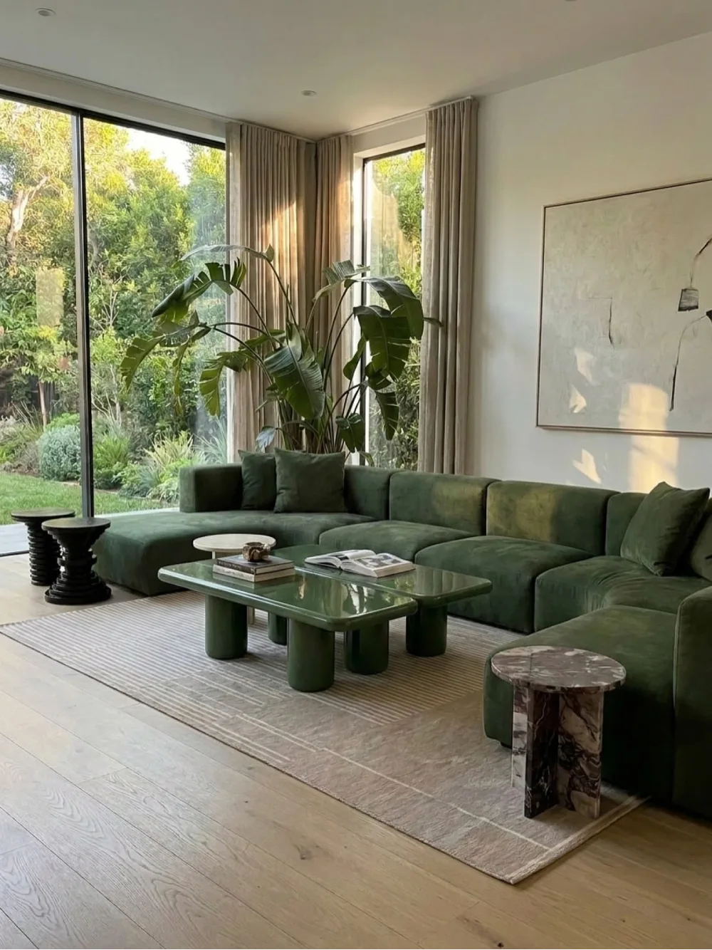 Deep green sectional in a bright living room surrounded by large plants