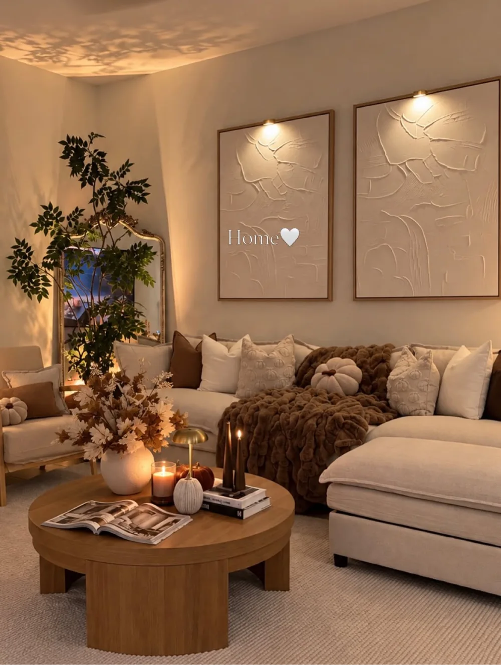 cozy neutral living room with warm lighting, chunky brown throw, candles, and wood coffee table