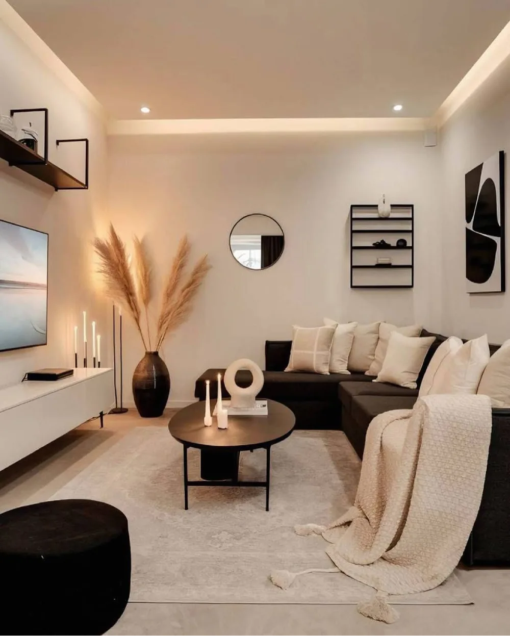 modern black and cream living room with sectional sofa, round coffee table, and minimalist artwork
