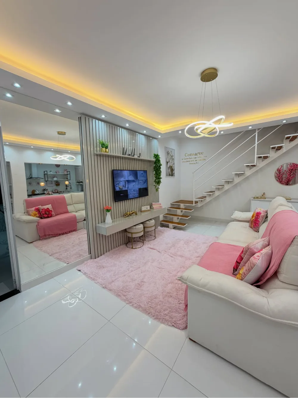 pink and white living room with plush rug, white sofas, pink accents, and warm ceiling lighting