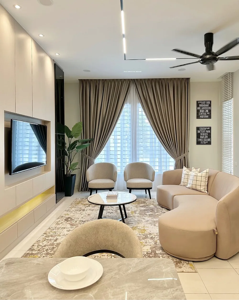 warm taupe living room with curved sofa, elegant curtains, and neutral decor