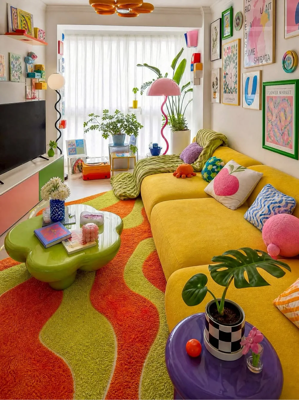 Colorful apartment living room with a bright yellow sectional, green and orange rug, and colorful artwork