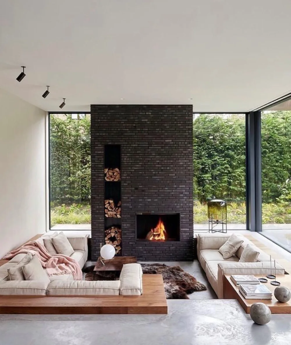 Sunken living room with cream sofas and a dark brick fireplace