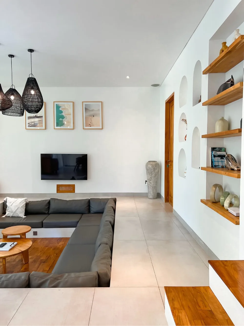 Minimalist sunken living room with a large gray sectional and wood accents
