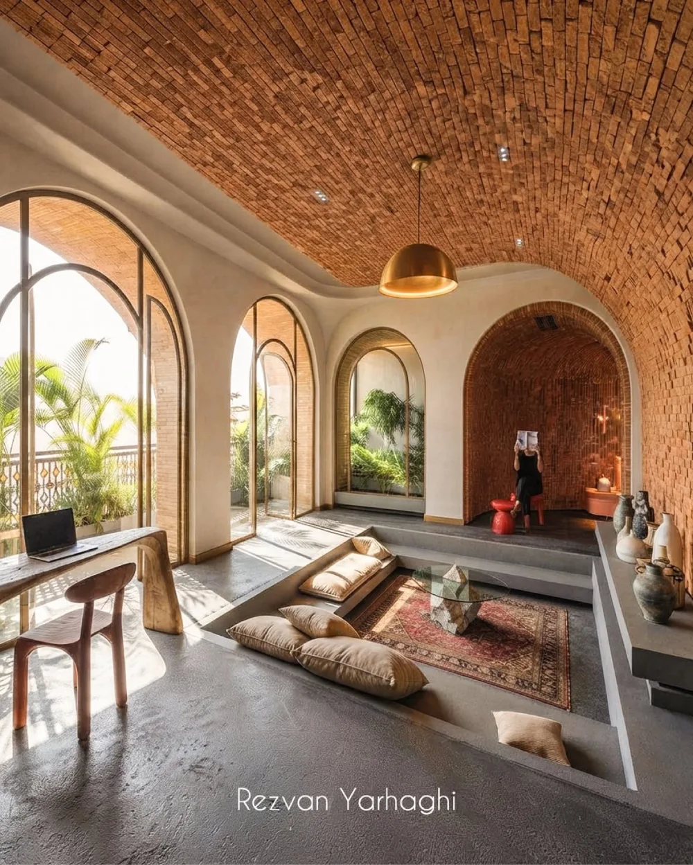 Arched sunken living room with floor cushions and exposed brick ceiling