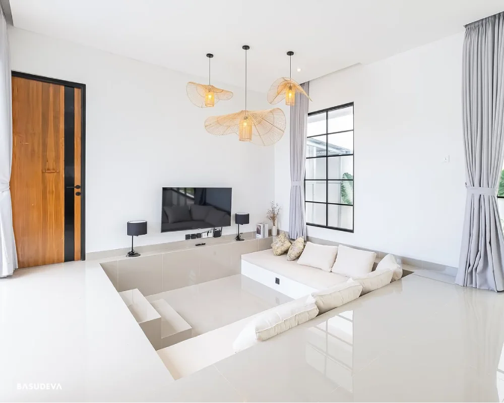 Bright all-white sunken living room with built-in sectional seating