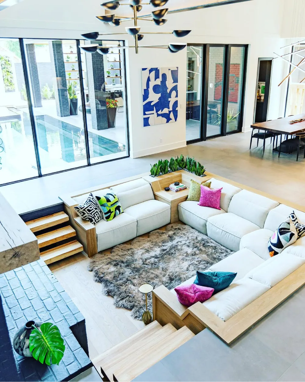 Colorful sunken family room with white sectional and bright accent pillows