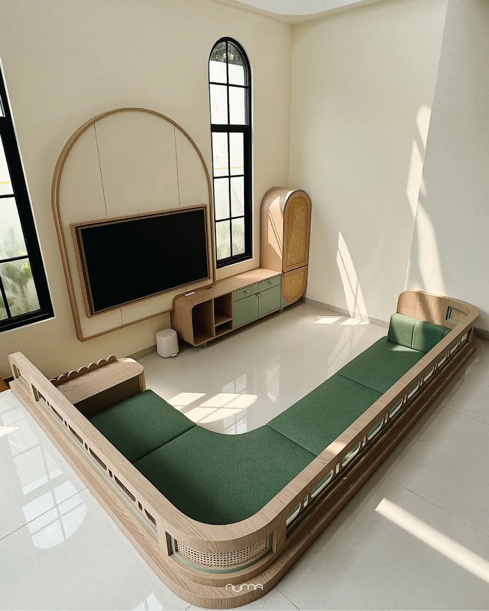 Sunken living room with green seating and arched windows