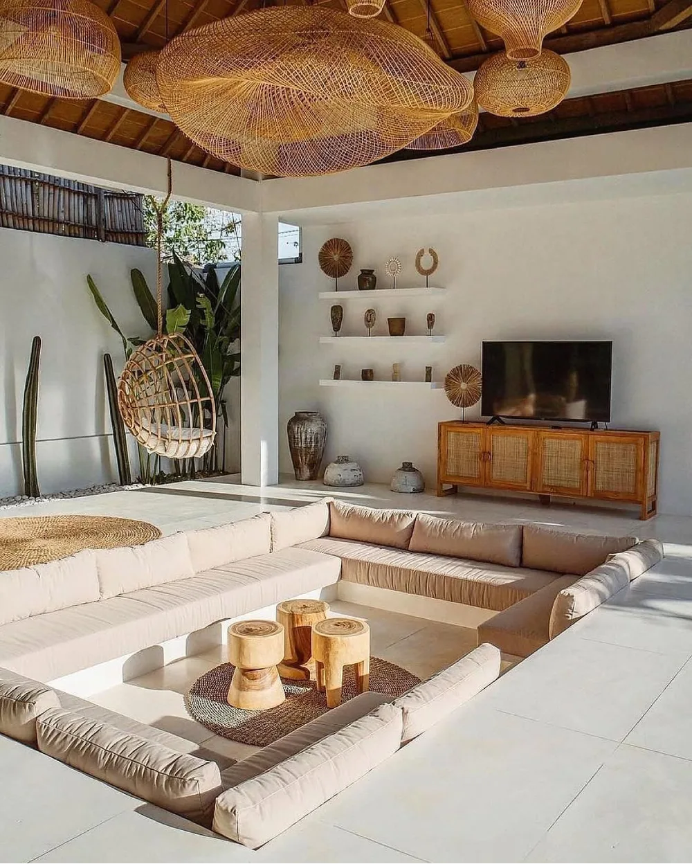 Natural sunken living room with cream seating and woven pendant lights