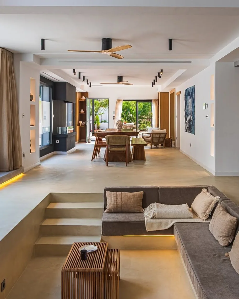 Modern sunken living room with a gray sectional and warm wood accents