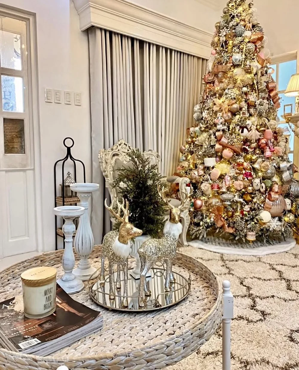 Glamorous Christmas living room with a heavily decorated gold and blush tree and silver reindeer