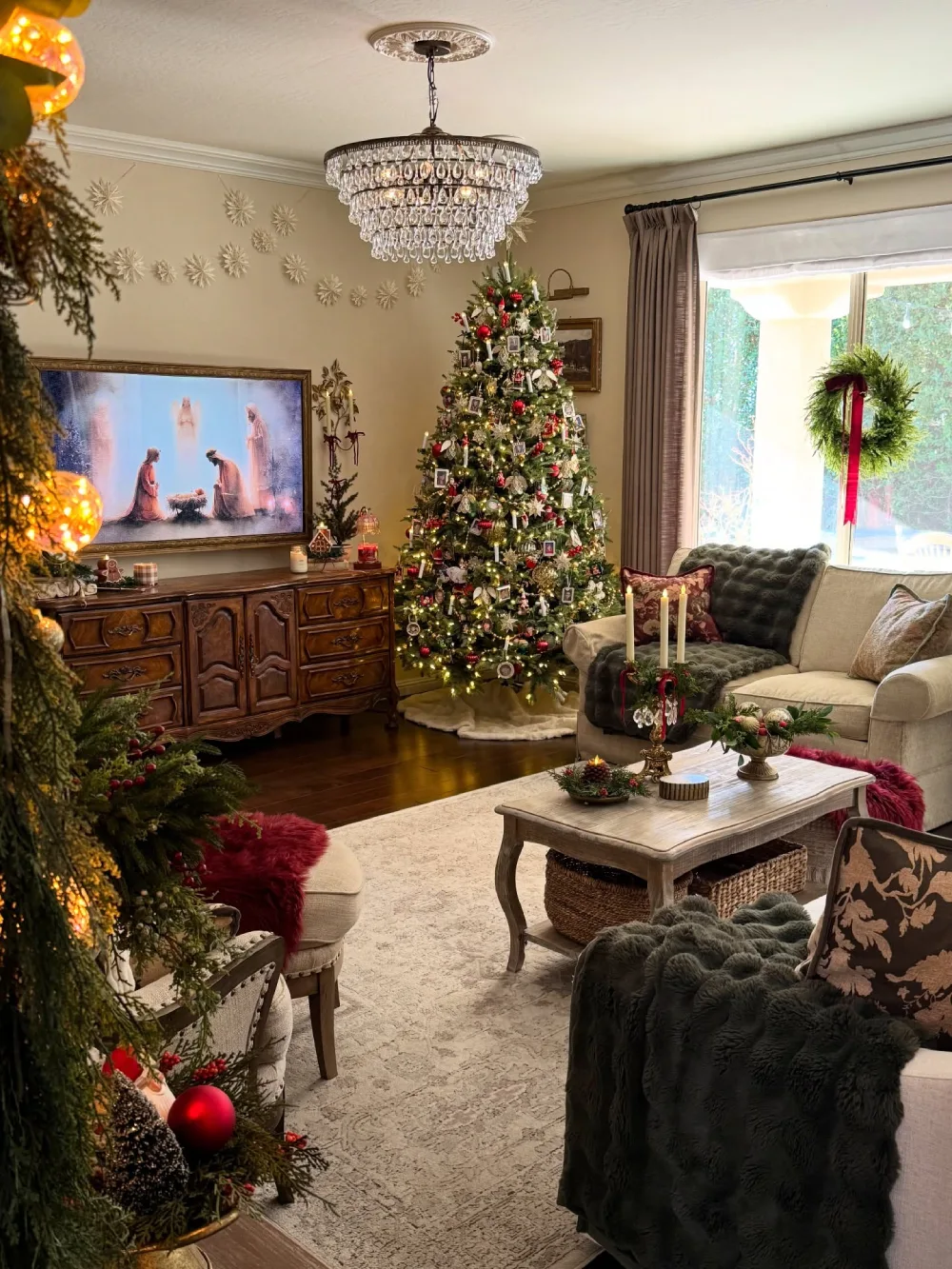 Traditional Christmas living room with a decorated tree, red throws, wood furniture, and warm lighting