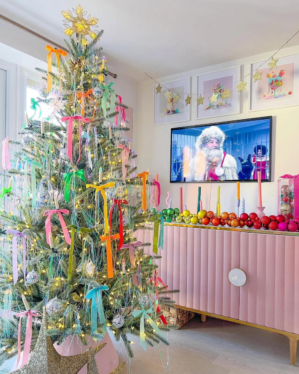 Colorful Christmas living room with pastel ribbons, rainbow ornaments, and a pink console
