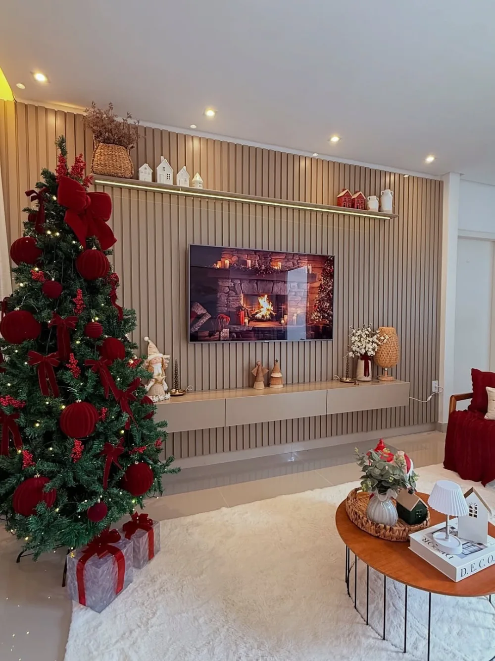 Neutral living room with a red Christmas tree, wood accent wall, and festive mantel decor