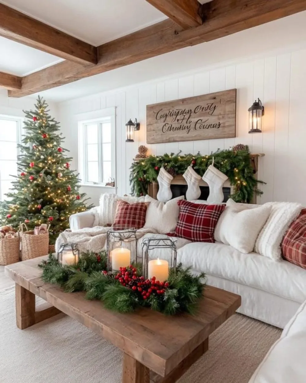 Rustic Christmas living room with white sofa, plaid pillows, greenery, candles, and wood coffee table