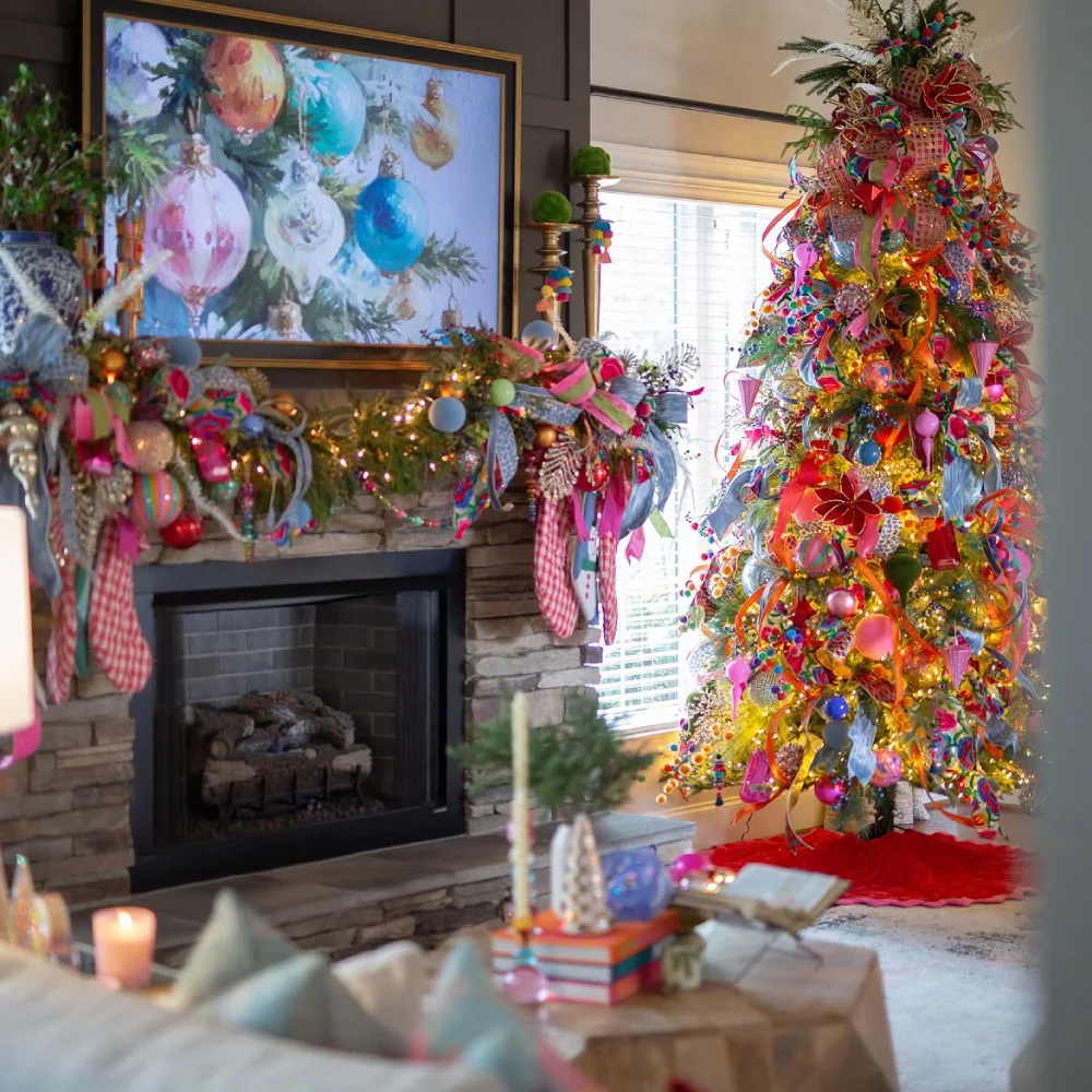 Maximalist Christmas tree covered with colorful ornaments and ribbons beside a decorated fireplace