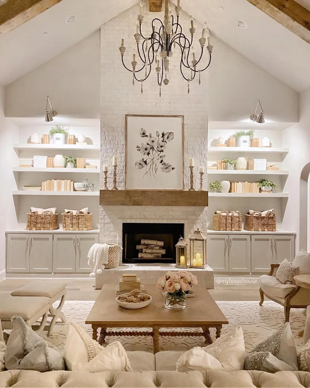 Farmhouse living room with a white brick fireplace, built-in shelves, woven baskets, neutral decor, and a rustic wood mantel
