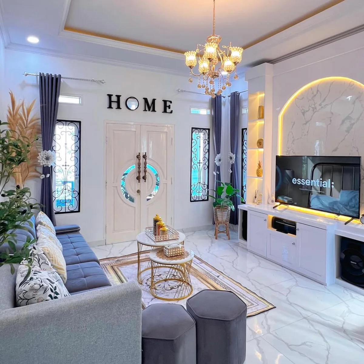 Elegant small living room with a gray sofa, gold accents, and a wall-mounted TV