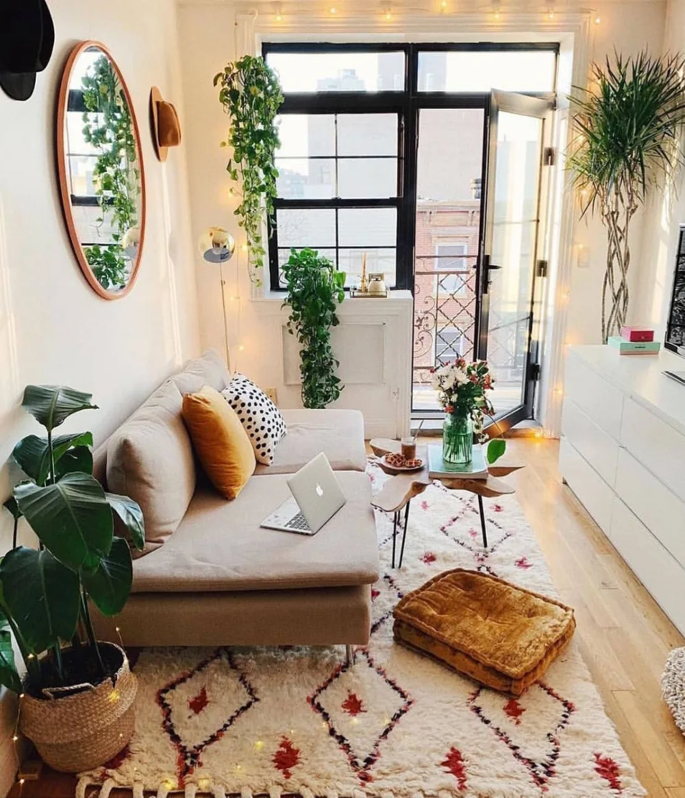 Small living room with a cream sectional sofa, round glass coffee table, and round ottoman