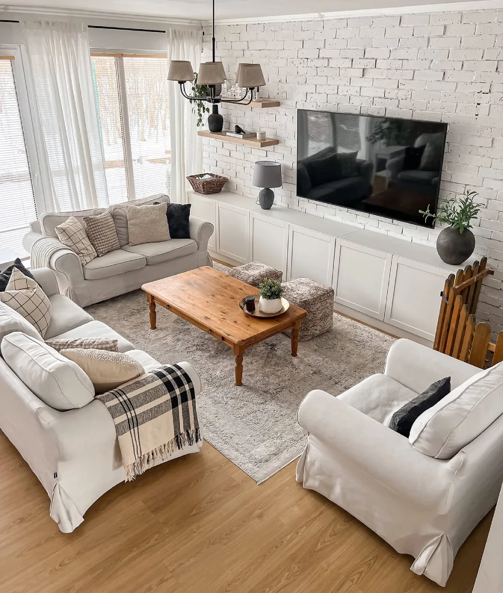 Cozy small living room with a cream sofa, wood coffee table, neutral artwork, and soft lighting