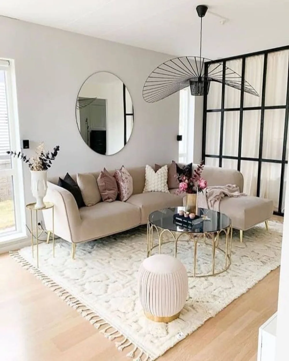 Bright small living room with a white sofa, large windows, light curtains, and minimalist decor