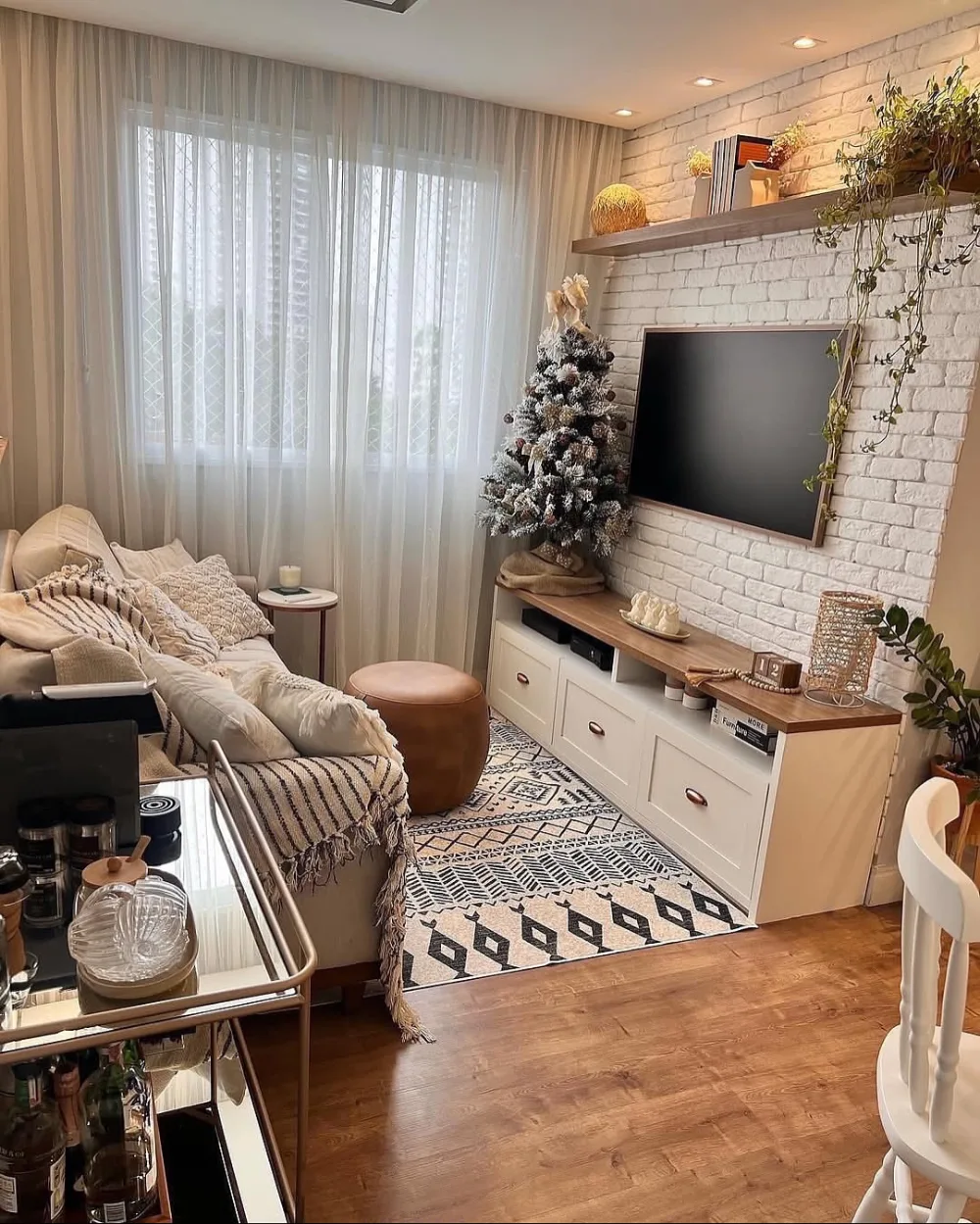 Small open living room with a light gray sectional, round coffee table, and spacious wood floor