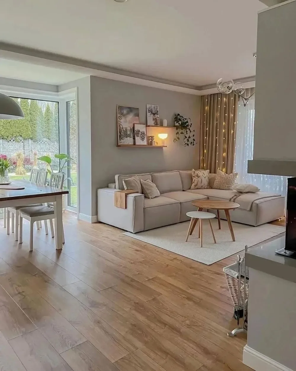 Cozy small living room with a neutral sofa, woven rug, plants, and warm wood accents