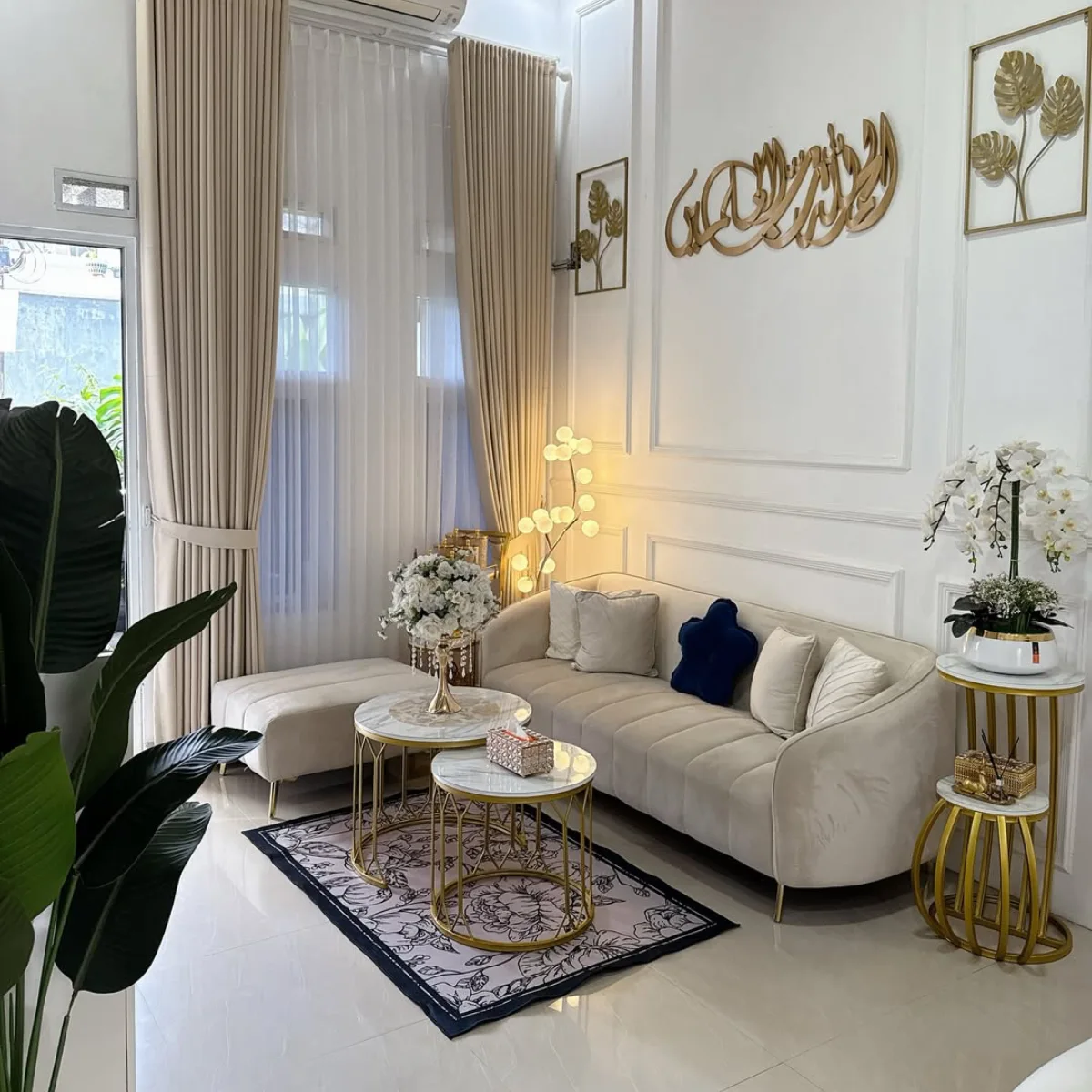 Small white living room with a compact sectional sofa, round tables, and gold side table