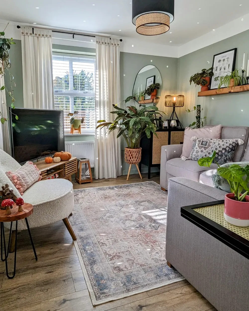 Small living room with open wood shelves, plants, a cream sofa, and warm floor lamp
