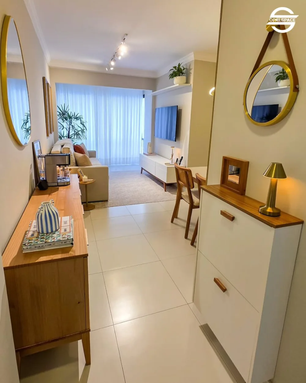 Small open-plan living room with cream sofa, round coffee table, compact kitchen, and dining area