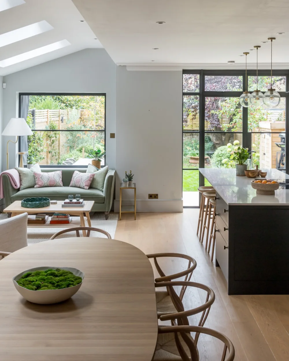 Open-concept dining area with wooden table, living room, and kitchen island