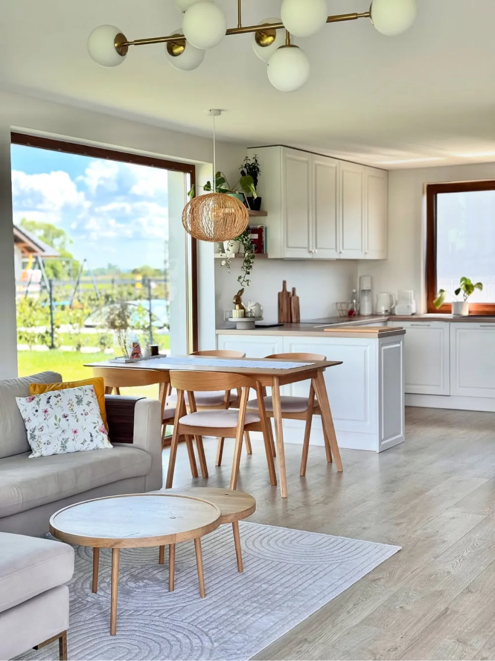 Open-concept living room with a wood dining table beside a white kitchen