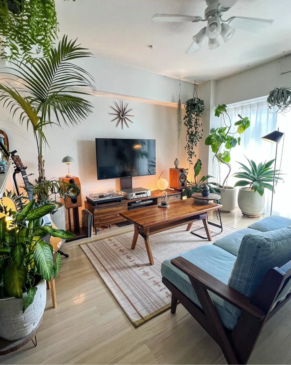 midcentury living room with houseplants surrounding a TV and media console