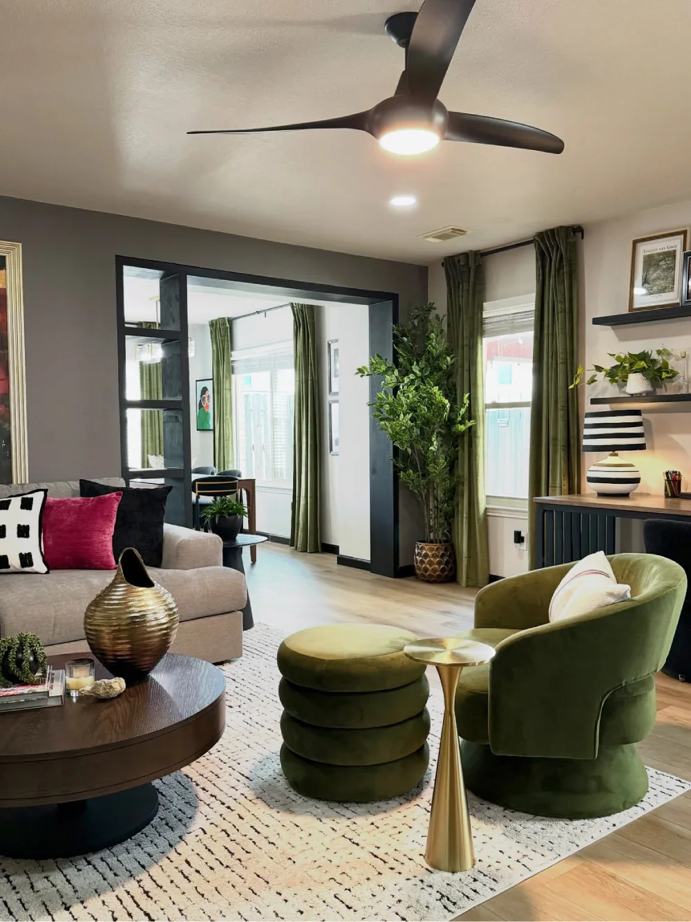 Modern living room with olive green chairs and ottoman, indoor plants, dark wood table, and neutral sofa