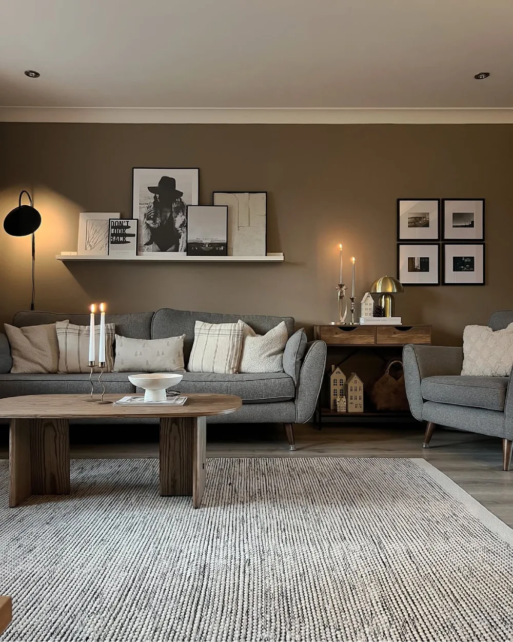 Gray sofa and armchair against a warm brown wall with wood furniture