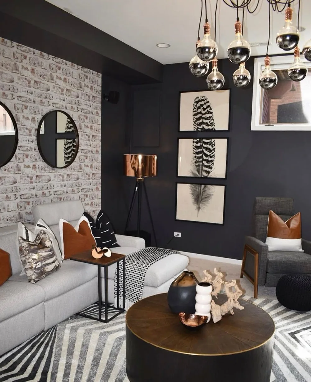 Gray sofa and brown coffee table against a dark wall with black and white decor
