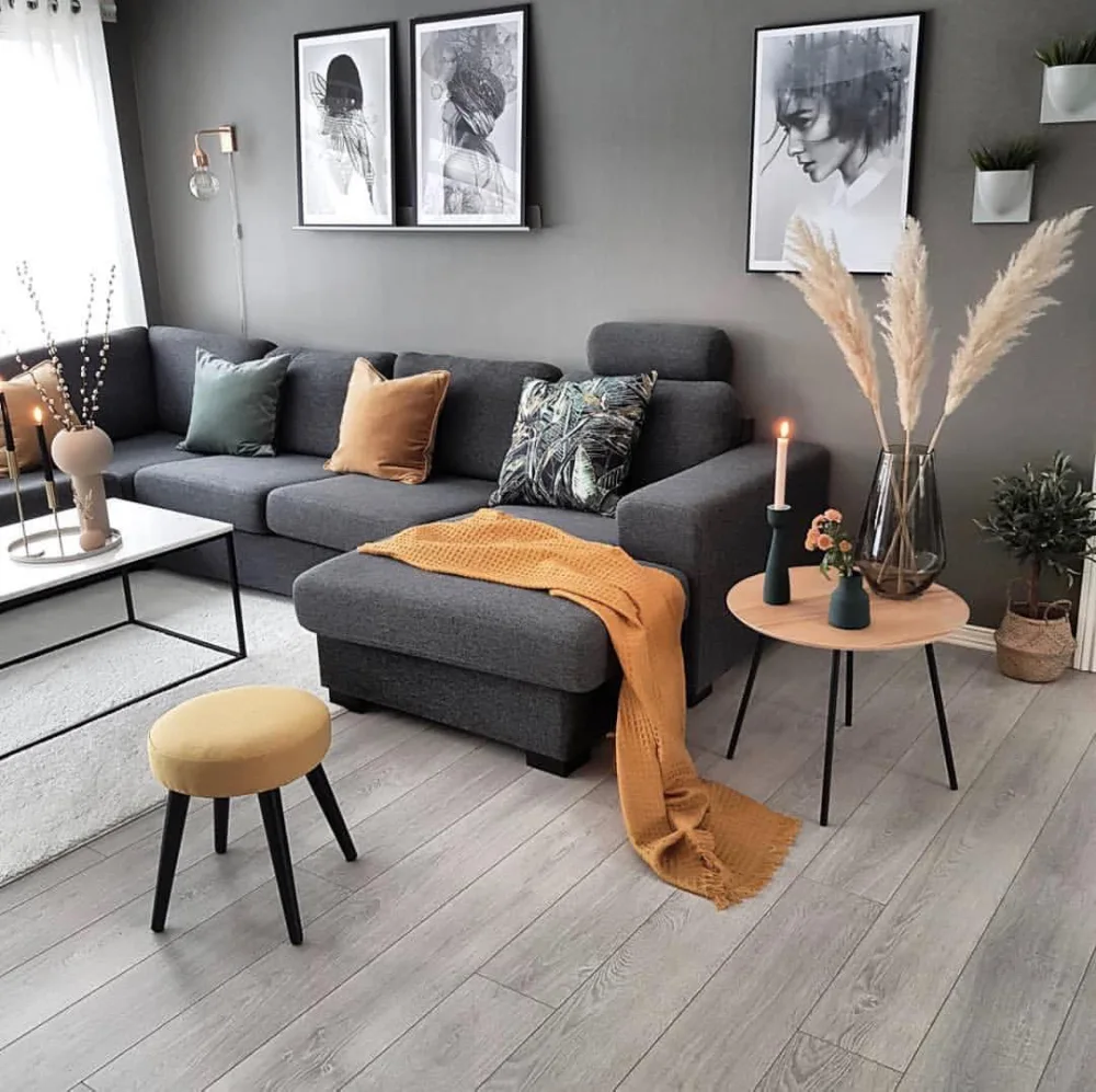 Charcoal gray sofa with brown pillows and warm wood furniture in a cozy living room