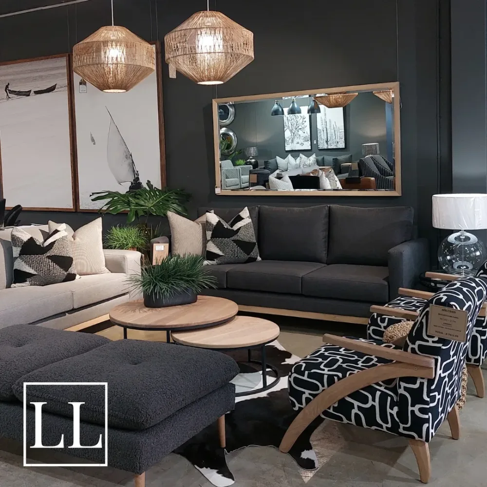 Dark gray sofa with natural wood tables, woven pendant lights, and neutral pillows