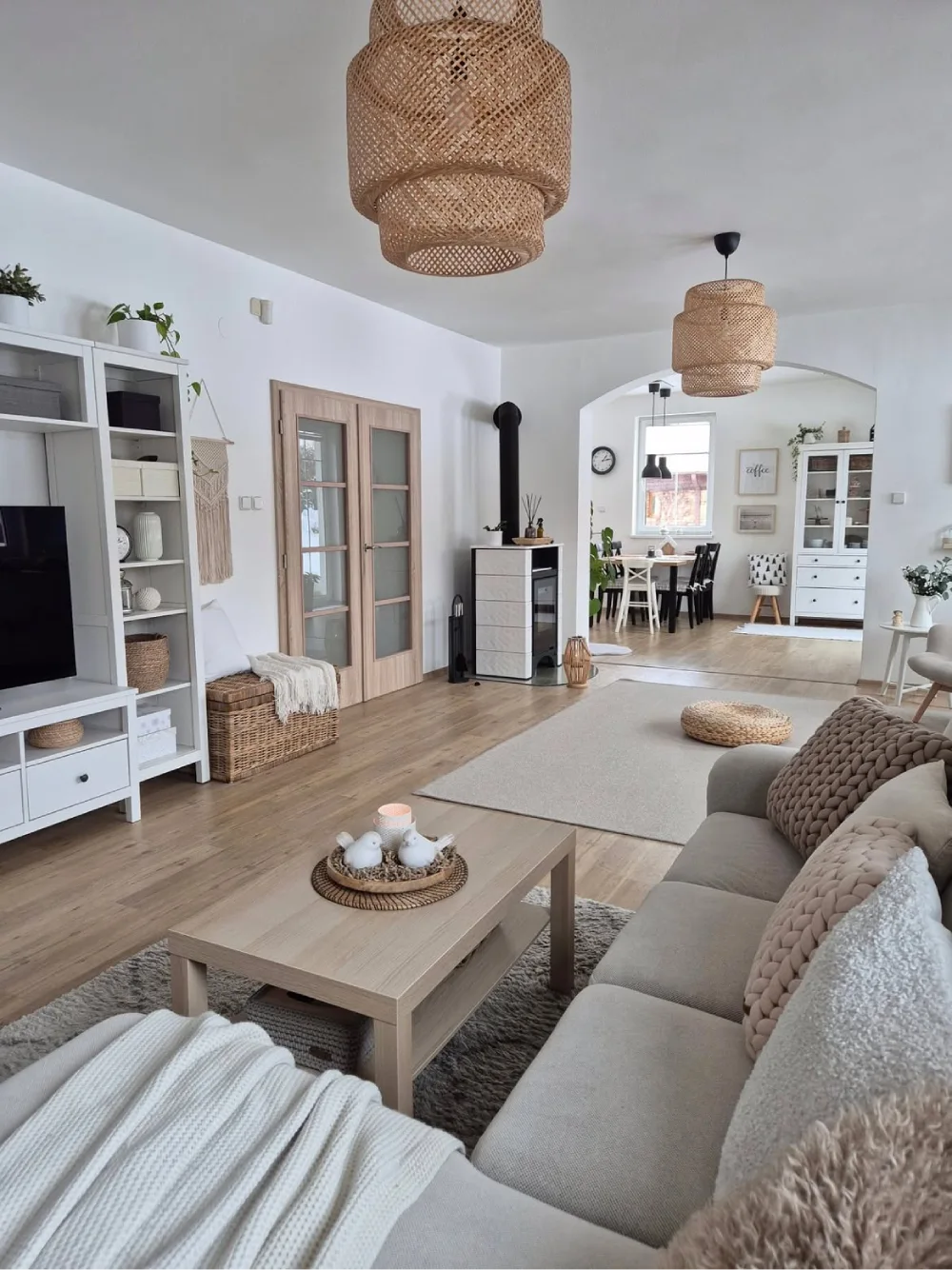 Neutral living room with beige sofa, woven pendant lights, soft rugs, and natural textures