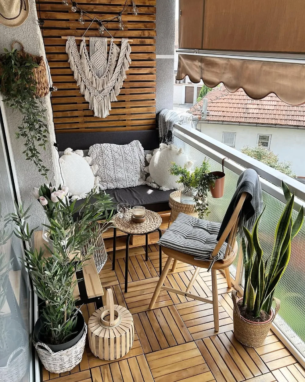 cozy balcony with wooden flooring, cushioned bench, plants, and macrame decor