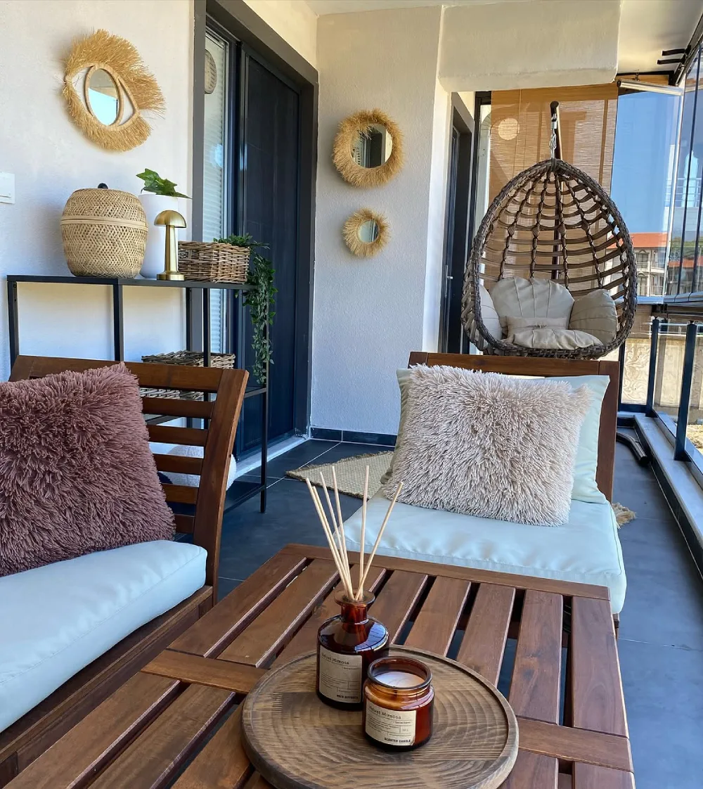 balcony with hanging wicker chair, wood furniture, and textured cushions