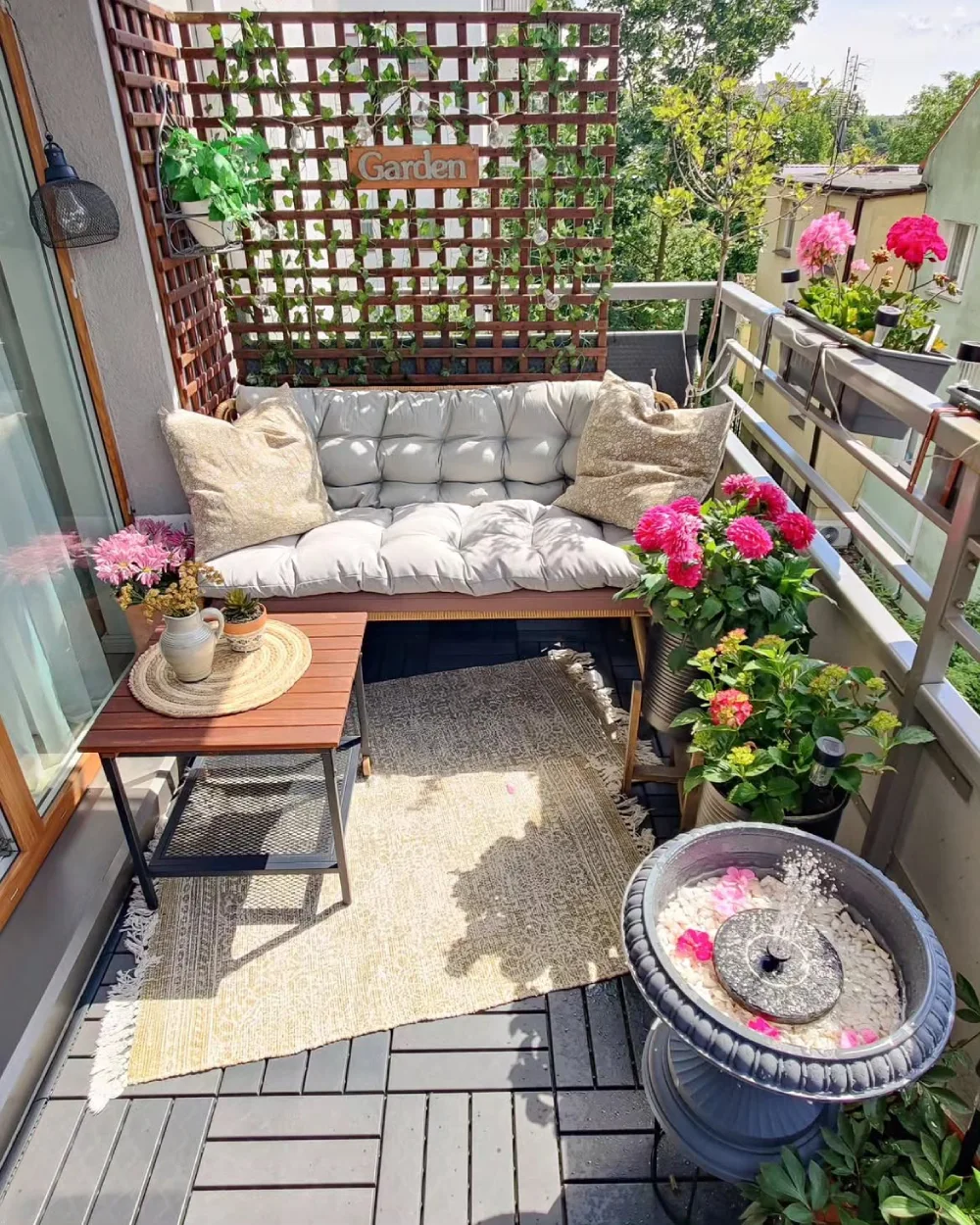 balcony garden with cushioned sofa, flowering plants, and wooden trellis