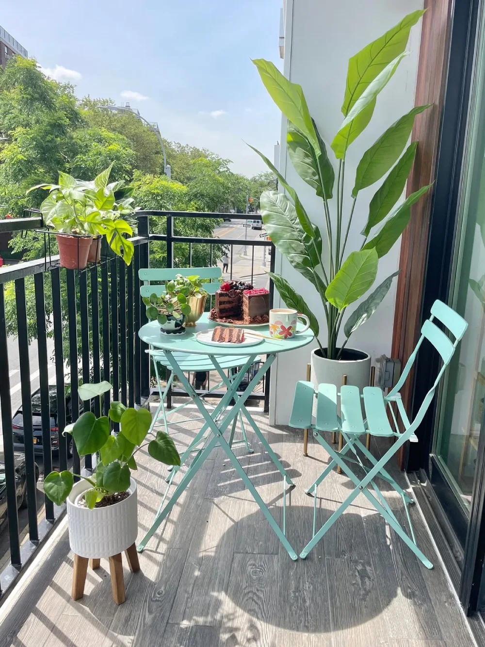 small balcony with turquoise bistro furniture and tropical plants
