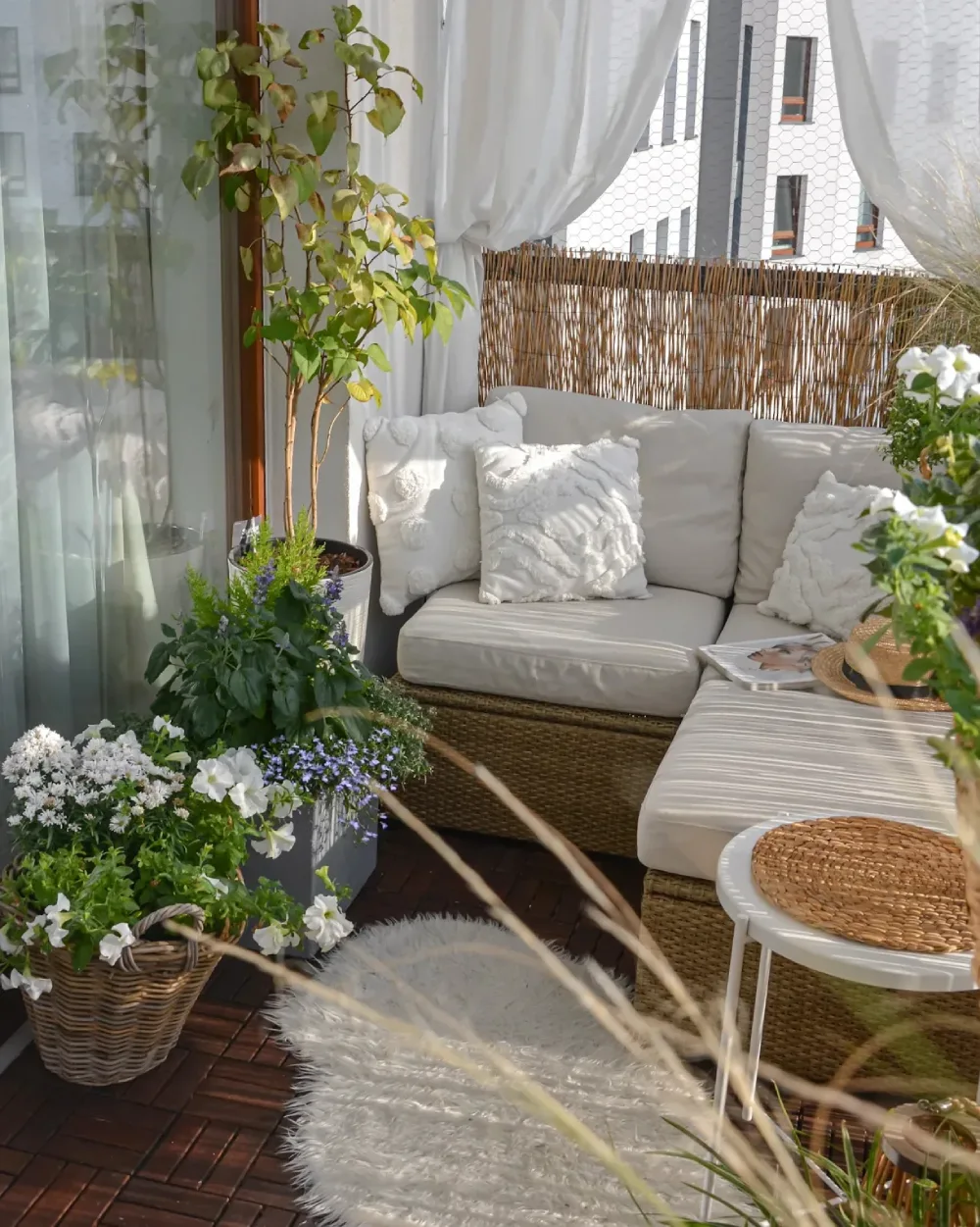 serene balcony with white sofa, sheer curtains, and flowering plants
